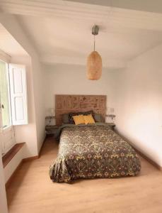 a bedroom with a bed with a blanket on it at La Casita de Coya 