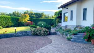 un jardín con una casa y una pasarela de ladrillo en Garden Villa, en Štanjel