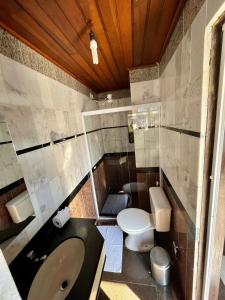 a bathroom with a toilet and a sink at Pousada Novo Encanto Maresias in Maresias