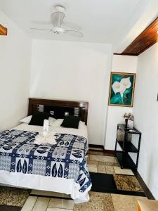 a bedroom with a bed with a blue and white comforter at Pousada Novo Encanto Maresias in Maresias