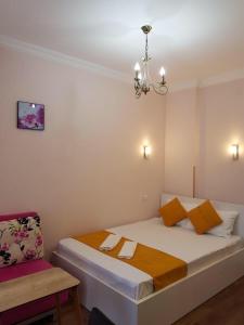 1 dormitorio con 1 cama con lámpara de araña y silla en Квартира у моря Колхида en Makhinjauri