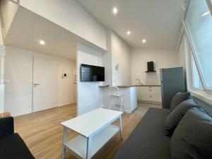 una sala de estar con un sofá y una mesa en Magnifique appartement Narbonne, en Narbona