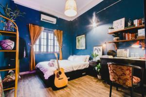 um quarto com uma cama com uma guitarra em CAMP Dakao a curated accomodation em Ho Chi Minh