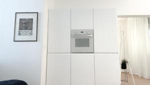 里米尼的住宿－Atelier Rimini - Affitti Brevi Italia，厨房配有白色橱柜和炉灶。