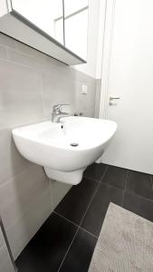 y baño con lavabo blanco y espejo. en Atelier Rimini - Affitti Brevi Italia, en Rímini