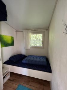 een bed in een kamer met een raam bij ZP 470 - Camping de Zandput in Vrouwenpolder