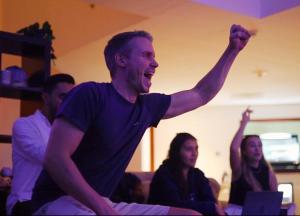 a man with his arm up in the air with people at Palm view hostel in Dubai