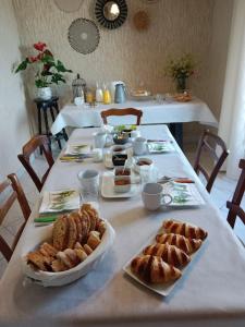 a table with bread and pastries on it at Chambre d'hôtes l'Hermione in Villeneuve-sur-Vère