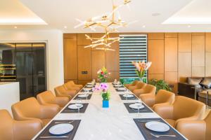 a long dining room with a long table and orange chairs at Ocean Villa Pool Retreat In Da Nang in Da Nang