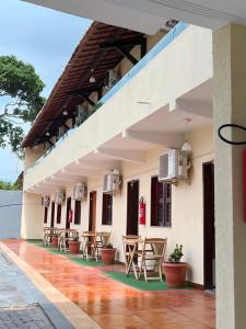 a patio of a building with tables and chairs at Hotel Pinto Martins in Camocim