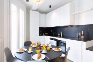 uma cozinha com uma mesa com comida para o pequeno almoço em Magnificent renovated 4-room apartment - Croisette Carre d'or em Cannes