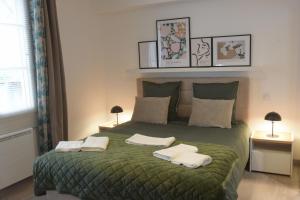 a bedroom with a green bed with towels on it at Loft Rossini Escapade Charmante à Narbonne in Narbonne