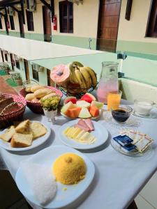 a table topped with plates of food and fruit at Hotel Pinto Martins in Camocim