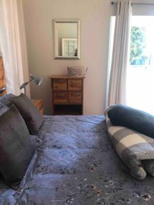 um quarto com uma cama e uma cómoda com uma janela em Self-catering two-bedroom flat Scottsville PMB em Pietermaritzburg