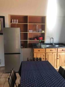 uma cozinha com um frigorífico e uma mesa com cadeiras em Self-catering two-bedroom flat Scottsville PMB em Pietermaritzburg