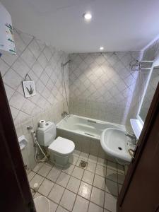 a bathroom with a tub and a toilet and a sink at Rose Beach Villas in Durat  Alarous
