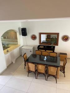 a dining room with a table and chairs and a mirror at Rose Beach Villas in Durat  Alarous