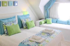 1 dormitorio con 2 camas con almohadas verdes y azules en Posada Suiza by Prima Collection en San Miguel del Monte