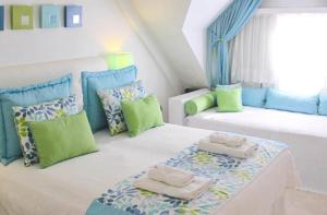 a bedroom with two beds with green and blue pillows at Posada Suiza by Prima Collection in San Miguel del Monte
