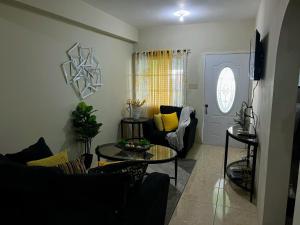 a living room with a couch and a table at Homely Escape in Montego Bay