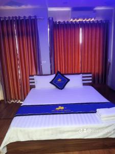 um quarto com uma cama grande e cortinas vermelhas em Điêu Thuyền Motel em An Khê