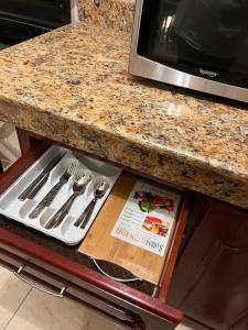 a kitchen counter with a drawer with utensils on it at Homely Escape in Montego Bay