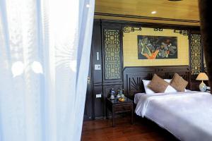 a bedroom with a bed and a painting on the wall at Cozy Boutique Cruise in Cat Ba