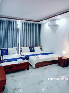 een slaapkamer met 2 bedden en een tafel. bij Điêu Thuyền Motel in An Khê