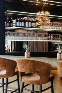 a bar with two chairs and a counter with bottles at Hotel Lugano in Knokke-Heist