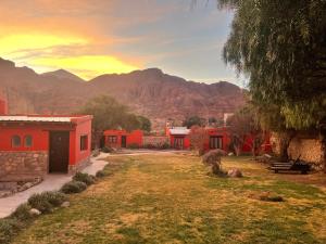 a village with red houses and mountains in the background at Posada Con Los Ángeles in Tilcara