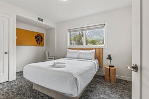 a bedroom with a large bed with a window at Basecamp Resorts Canmore in Canmore