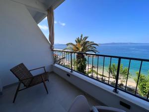 Un balcón con una silla y vistas al océano. en Beachfront Comfort Apartments SINAJKO en Podgora