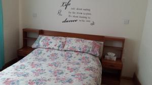 um quarto com uma cama com flores na parede em Weaver's House B and B em Cardiff