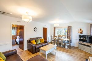 a living room with a couch and a table at Heather Lodge 1 with Hot Tub in Belladrum +17 photos