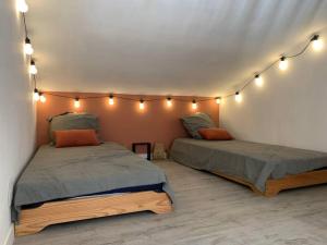 two beds in a room with lights on the wall at Casa del Sola in Mosset