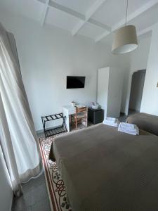a bedroom with a bed and a table and a television at La Musa in Capri