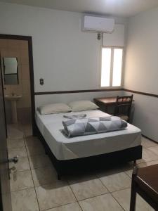 - une chambre avec un lit, une table et une fenêtre dans l'établissement ORSI HOTEL, à Araguari