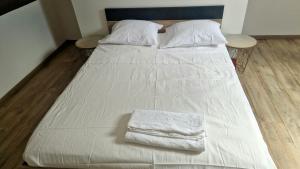 ジボールにあるGivors Centre Duplex meubléのベッド(白いシーツ2枚、枕付)