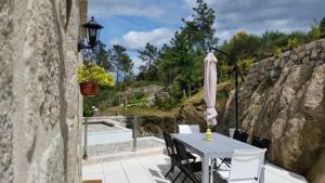 a patio with a table and an umbrella at Casa da Gandarela in Soajo