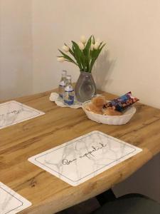 einen Holztisch mit zwei Platten und eine Vase mit Blumen in der Unterkunft Ferienwohnung Krayenbergblick 2 