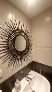 łazienka z umywalką i lustrem na ścianie w obiekcie Givors Centre Duplex meublé w mieście Givors