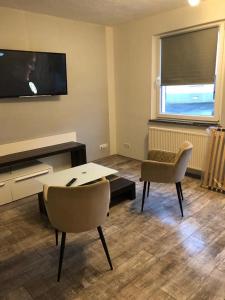 a living room with a tv and a table and chairs at Ferienwohnung Krayenbergblick 2 