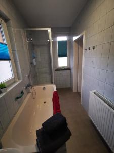 ein großes Bad mit einer Badewanne und einer Dusche in der Unterkunft Ferienwohnung Krayenbergblick 2 