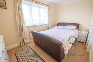 een slaapkamer met een bed en een raam bij Pittlesden Cottage - Sleeps 4 - Tenterden in Tenterden