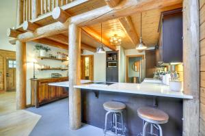 Gaston的住宿－Luxe Cabin in the Woods Walk to Lake!，开放式厨房设有木墙和木凳