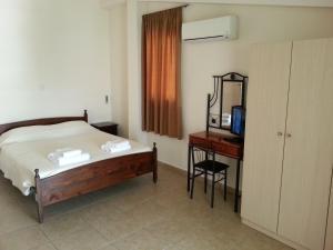 a bedroom with a bed and a desk with a television at St. Lazaros House in Larnaka
