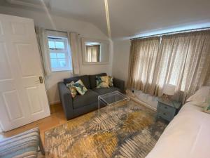 uma sala de estar com um sofá e uma janela em The Guesthouse hideaway em Hordle