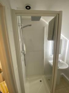 ein Bad mit einer Dusche und einem Waschbecken in der Unterkunft The Guesthouse hideaway in Hordle