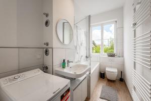 uma casa de banho branca com um lavatório e um espelho em unique Billroth Residenz 16 - Dresden em Dresden