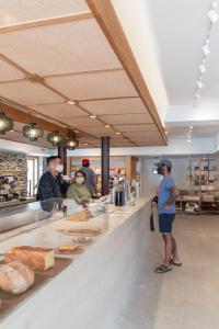 a group of people standing at a counter in a bakery at guesthouse by good neighbor in Baltimore